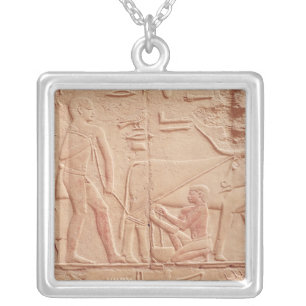Relief depicting a man milking a cow silver plated necklace