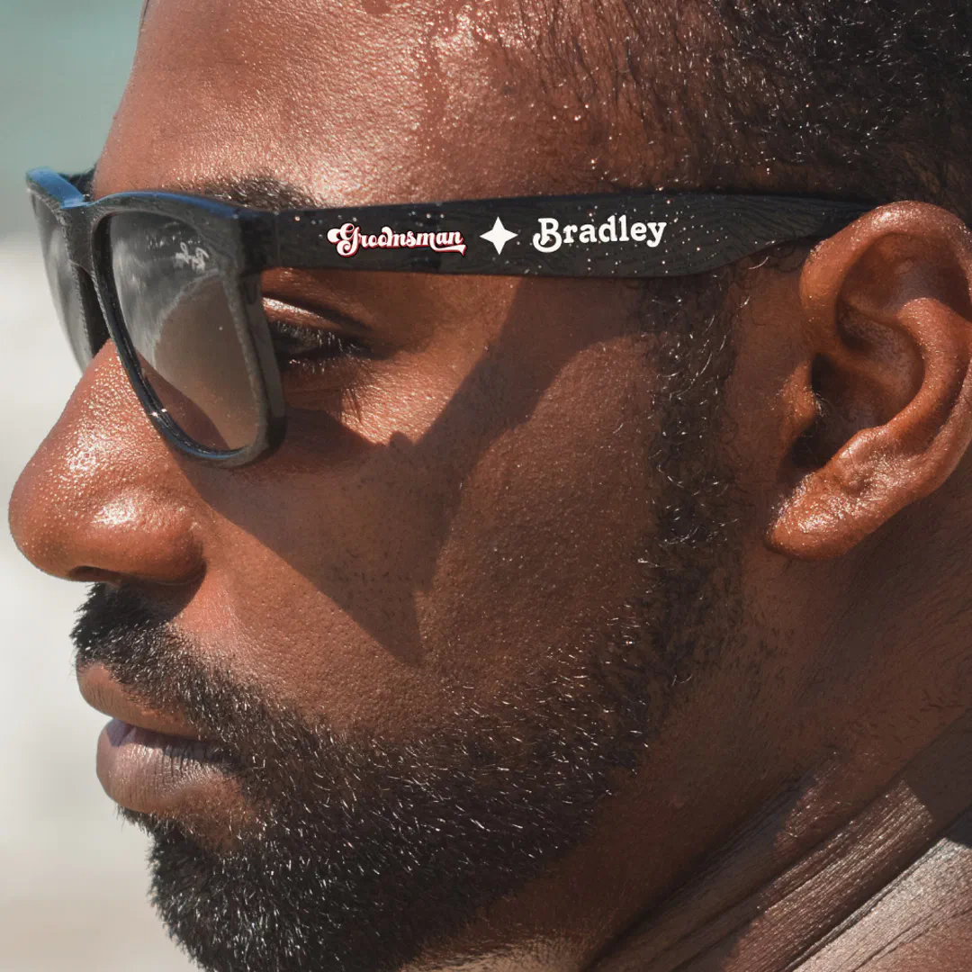 Man wearing retro black and white groomsman sunglasses with a custom design.