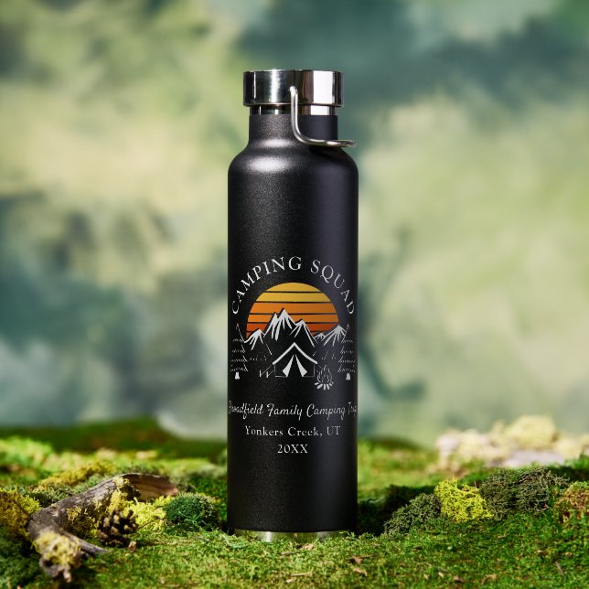 A water bottle is pictured atop a mossy tree. 