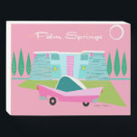 Retro Pink Palm Springs Wood Box Sign<br><div class="desc">Between the pink background, turquoise mid century modern home, and the classic 1950s car, this design couldn’t be more Palm Springs if it said it in the clouds. Oh, wait, it does say it in the clouds! The blue and teal stone of the house is offset by the sputnik light...</div>