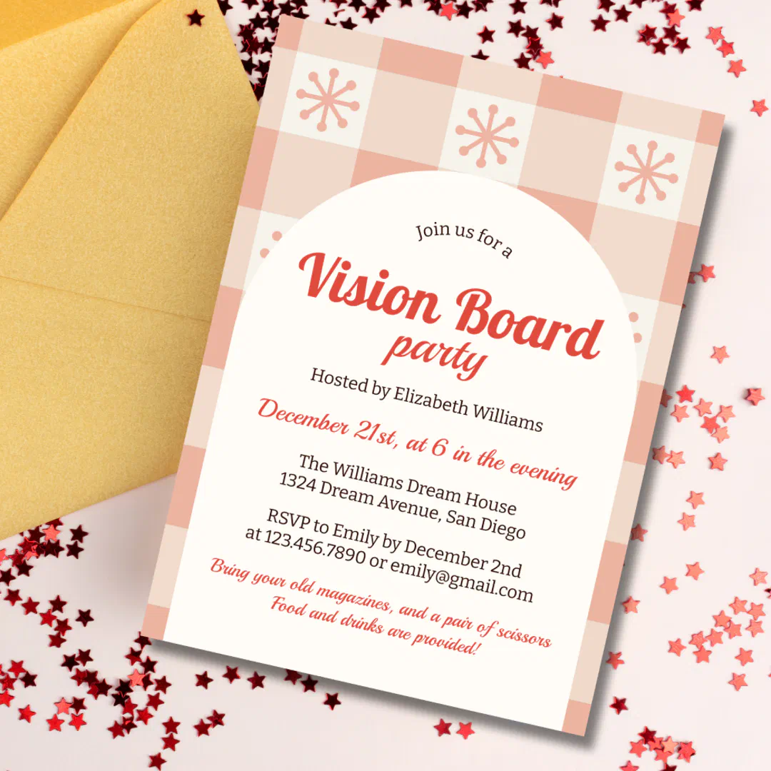 A vision board party invitation with a cream arch over a pink checkered pattern dotted with retro snowflakes, angled beside a gold envelope on a pale pink surface scattered with red star confetti.