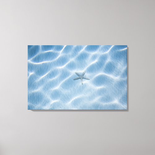 Rippled blue water with starfish canvas print