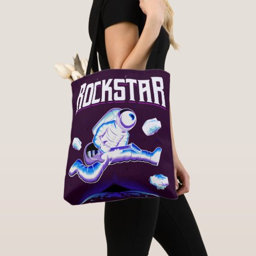 Rockstar astronaut playing guitar in space  tote bag