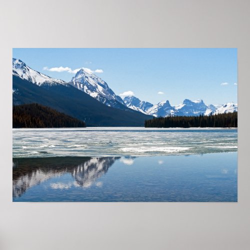 Rocky mountains reflecting in Maligne lake Poster