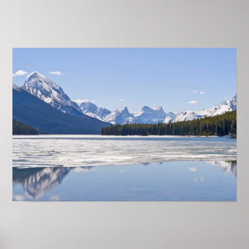 Rocky mountains reflecting in Maligne lake Poster