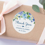 Romantic Blue Hydrangeas Floral Wedding Thank You Classic Round Sticker<br><div class="desc">Add a touch of elegance to your wedding favors with these Romantic Blue Hydrangeas Floral Thank You Stickers. These stickers feature beautiful blue hydrangeas and a customizable thank you message to show your appreciation to your guests. The stickers come in a round shape and are perfect for sealing envelopes or...</div>