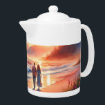 Romantic Coastal Sunset Lighthouse Walk Teapot<br><div class="desc">A dreamy coastal scene unfolds at golden hour, where a couple strolls along the shoreline beneath a glowing sunset and a distant lighthouse. Soft pastel skies blend coral, peach, and warm amber tones with rolling ocean waves, creating a tranquil, romantic atmosphere. The painterly style feels whimsical and cozy, evoking cottagecore...</div>