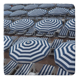 Rows Of Striped Beach Umbrellas With Sun Beds Trivet
