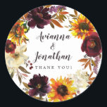Rustic Autumn Floral Wedding Thank You Favor Classic Round Sticker<br><div class="desc">Dramatic fall flowers include yellow sunflowers, purple peonies, dark red roses, and ivory white hydrangeas. They are nestled in fall leaves and vines to create a very pretty wreath. The wedding couple names are written in a large script font. Thank you sentiment follows This wedding sticker is part of the...</div>