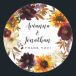 Rustic Autumn Floral Wedding Thank You Favor Classic Round Sticker<br><div class="desc">Dramatic fall flowers include yellow sunflowers, purple peonies, dark red roses, and ivory white hydrangeas. They are nestled in fall leaves and vines to create a very pretty wreath. The wedding couple names are written in a large script font. Thank you sentiment follows This wedding sticker is part of the...</div>