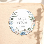 Rustic Boho Dusty Blue Flowers Wedding Classic Round Sticker<br><div class="desc">Introducing our Personalized Wedding Sticker, a harmonious blend of rustic allure and contemporary elegance. This beautifully crafted sticker features a charming watercolor wreath, showcasing a delicate arrangement of neutral and dusty blue flowers. At the heart of this floral embrace, your names are elegantly inscribed in a classic serif font, seamlessly...</div>
