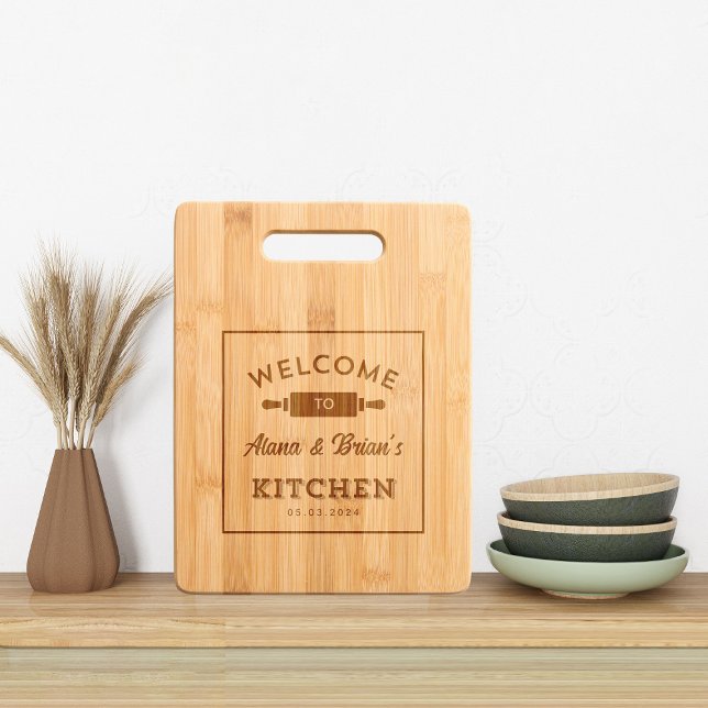 Rustic Etched Welcome To Kitchen with Name & Date Engraved Cutting Board (Engraved Couple Name Welcome Kitchen Bamboo Cutting Board kitchen decor mock up )