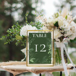 Rustic Fern Green Foliage Emerald Wedding Table Number<br><div class="desc">Introducing our enchanting wedding table number where elegance meets nature in perfect harmony. A soft, feathery oval frame adorned with lush forest greenery, ivy, ferns, and more, beautifully set against a mesmerizing emerald green background. Capture the essence of a romantic woodland escape with this stunning design that will leave your...</div>