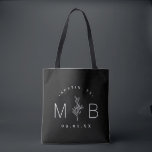 Rustic Floral Stem Wedding Monogram | Black Tote Bag<br><div class="desc">Custom printed tote bags make a fun and functional wedding favor your guests will love! Personalize the template with the bride and groom's names or monogram initials. Add your wedding date, the city, state or venue name or any other custom text. This modern rustic logo-style design has a simple floral...</div>