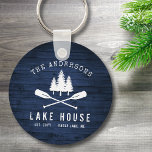 Rustic Lake House Oars Trees Blue Wood Print Round Keychain<br><div class="desc">A beautiful, rustic themed round keychain, featuring your family name and "Lake House" or other desired text along with its established date and location. This custom, unique design features a white silhouette of crossed boat oars and pine trees on a print of wood planks in rich blue colors. Perfect for...</div>