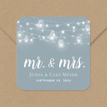 Rustic String Lights Mr. and Mrs. Wedding Monogram Square Sticker<br><div class="desc">Custom printed stickers personalized with your Mr. and Mrs. monogram and wedding date, perfect for wedding favor labels, welcome bags or envelope seals with your invitations. The design features glowing string lights and mason jars on a dusty blue background. Use the design tools to choose any background color, change the...</div>