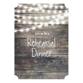Rustic wood and string lights rehearsal dinner card