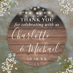 Rustic Wood String Lights Wedding Favor Thank You Classic Round Sticker<br><div class="desc">Rustic signature script wedding favor thank you classic round sticker featuring pretty string lights and signature style names on a wood panels background. Personalize with your special thank you information in chic white typography. Designed by Thisisnotme©</div>