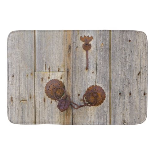 Rusty vintage old iron padlock on a wooden door __ bath mat