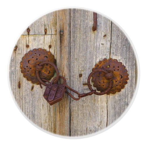 Rusty vintage old iron padlock on a wooden door _ ceramic knob