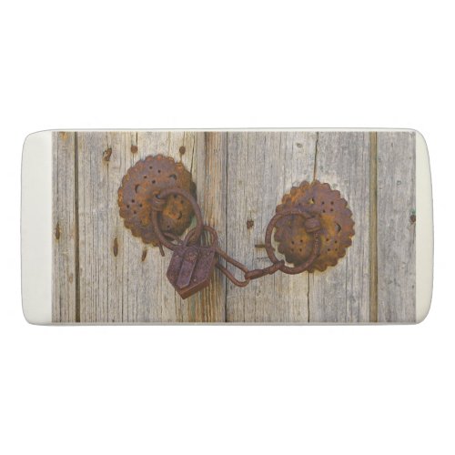 Rusty vintage old iron padlock on a wooden door eraser