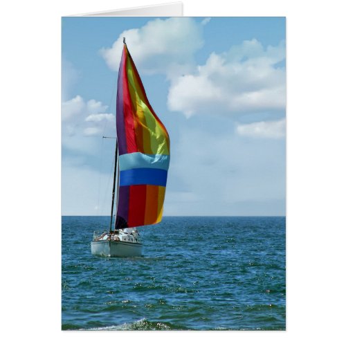 sailboat with rainbow spinnaker on water