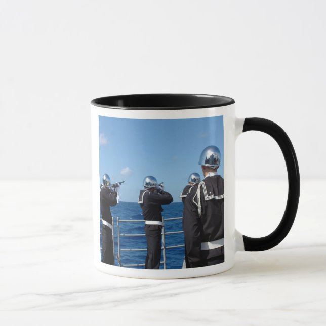 Sailors fire a gun salute during a burial-at-se mug (Right)