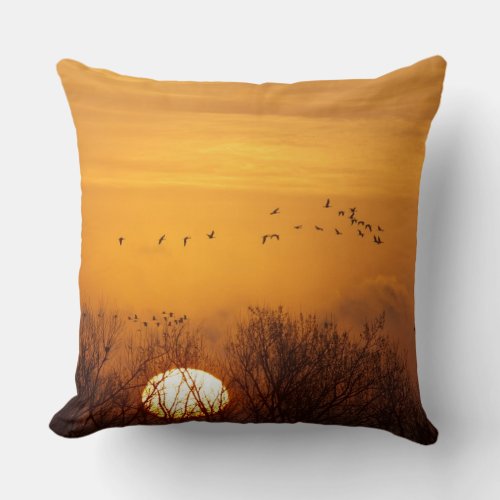 Sandhill cranes silhouetted aginst rising sun throw pillow