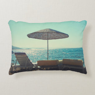 Sandy beach on a sunny afternoon, with parasols a accent pillow