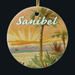 Sanibel Island Florida vintage beach Ceramic Ornament<br><div class="desc">Sanibel Island,  Florida commemorated with a vintage art beach sunset scene with palm trees and a boat. The name Sanibel is in a script font at the top.</div>