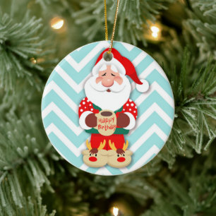 Santa claus in red pajamas holding a mug ceramic ornament
