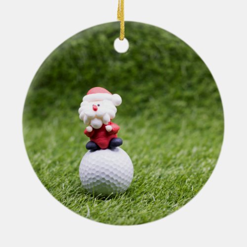 Santa Claus is sitting on golf ball Ceramic Ornament
