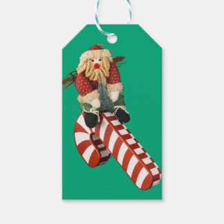 Santa Claus plays on candy can slide for fun. Gift Tags