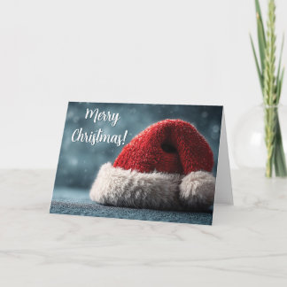 Santa Hat Resting on Snowy Surface with Greeting Card