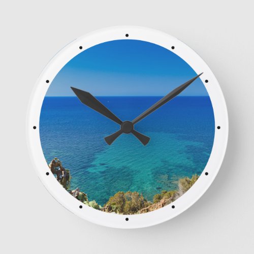 Sardinian blue sea and sky w mediterranean scrub round clock
