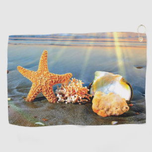 Sea shells and starfish on beach golf towel