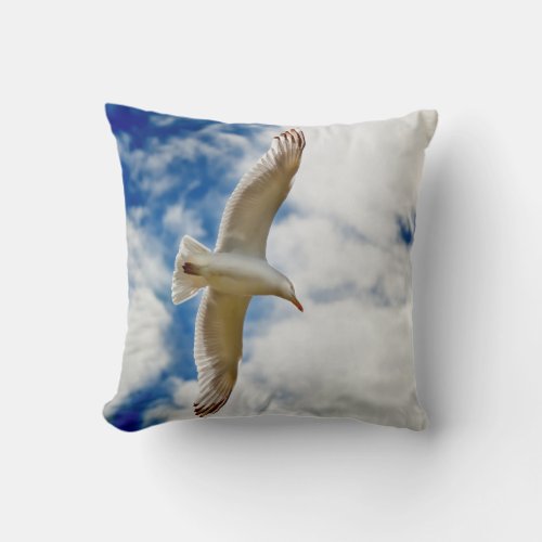 Seagul in flight with blue skies and white cloud throw pillow