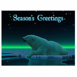 Season's Greetings - Ice Edge Polar Bear Statuette<br><div class="desc">A peaceful moment in the long Arctic night. A Polar Bear rests at the edge of an open area in the pack ice. The Northern Lights glow in the distance; bright stars twinkle overhead. "Season's Greetings" appears in glowing blue and white. Add your own text. Polar bears are endangered. How...</div>