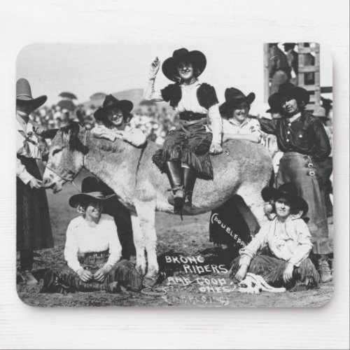 Seven rodeo cowgirls jokingly posing with a donkey mouse pad