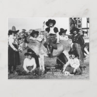 Seven rodeo cowgirls jokingly posing with a donkey