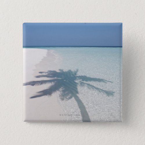Shadow of a palm tree on a deserted island beach pinback button