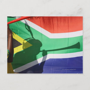 Shadow of soccer supporter blowing vuvuzela, postcard
