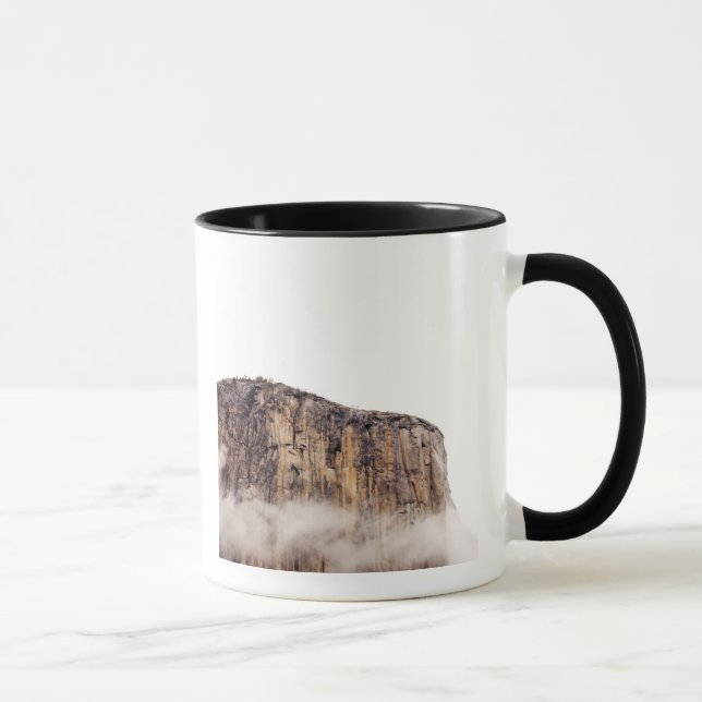Sheer cliff rising above clouds mug (Right)