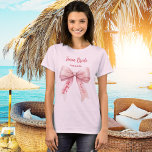 She's tying the knot pink bow Team Bride T-Shirt<br><div class="desc">An elegant soft pink background,  decorated with a pink colored bow. Personalize and add a name.
Text: Team Bride.  She's tying the knot.</div>