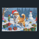 Shiba Inu Running in Snow with Christmas Hat Kitchen Towel<br><div class="desc">A spirited Shiba Inu runs joyfully through the snowy winter scene,  wearing a festive red Christmas hat. This charming design highlights the breed’s foxlike face,  curled tail,  and confident personality while capturing the warmth and joy of the holiday season. A delightful winter moment full of festive cheer.</div>