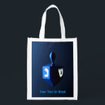 Shiny Blue Dreidel Reusable Grocery Bag<br><div class="desc">A modernistic,  metallic blue dreidel against a dark,  night-like background.  Two of the Hebrew letters found on a dreidel,  nun and shin,  glow brightly.  Add your own text.</div>