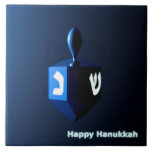 Shiny Blue Dreidel Tile<br><div class="desc">A modernistic,  metallic blue dreidel against a dark,  night-like background.  Two of the Hebrew letters found on a dreidel,  nun and shin,  glow brightly.  Text reading "Happy Hanukkah" also appears in glowing blue and white.</div>