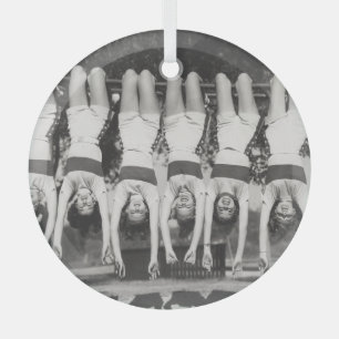 Showgirls on monkey bars, playful design. glass ornament
