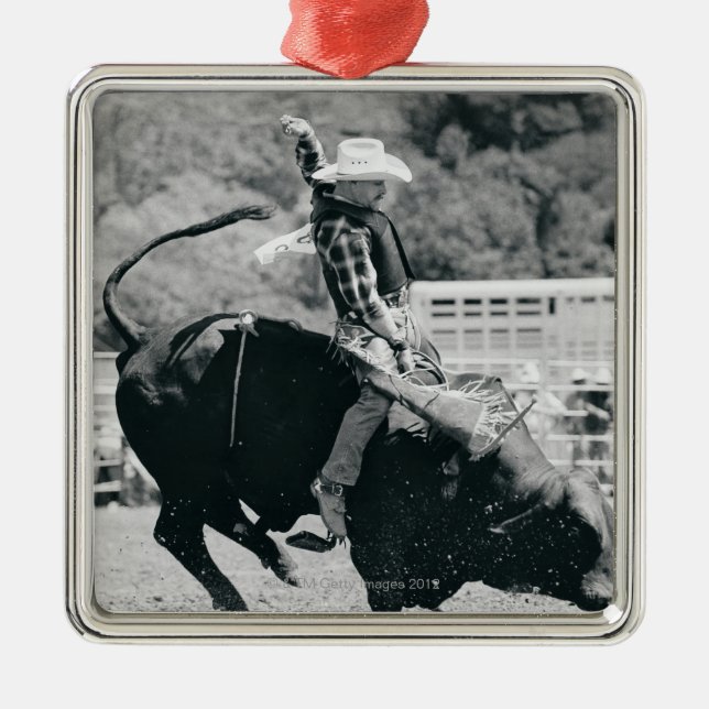 Side view of rider hanging on to bucking bull metal ornament (Front)