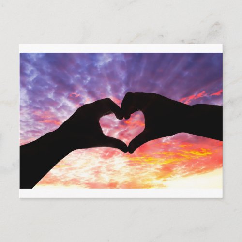 Silhouette hand in heart shape and beautiful sky postcard